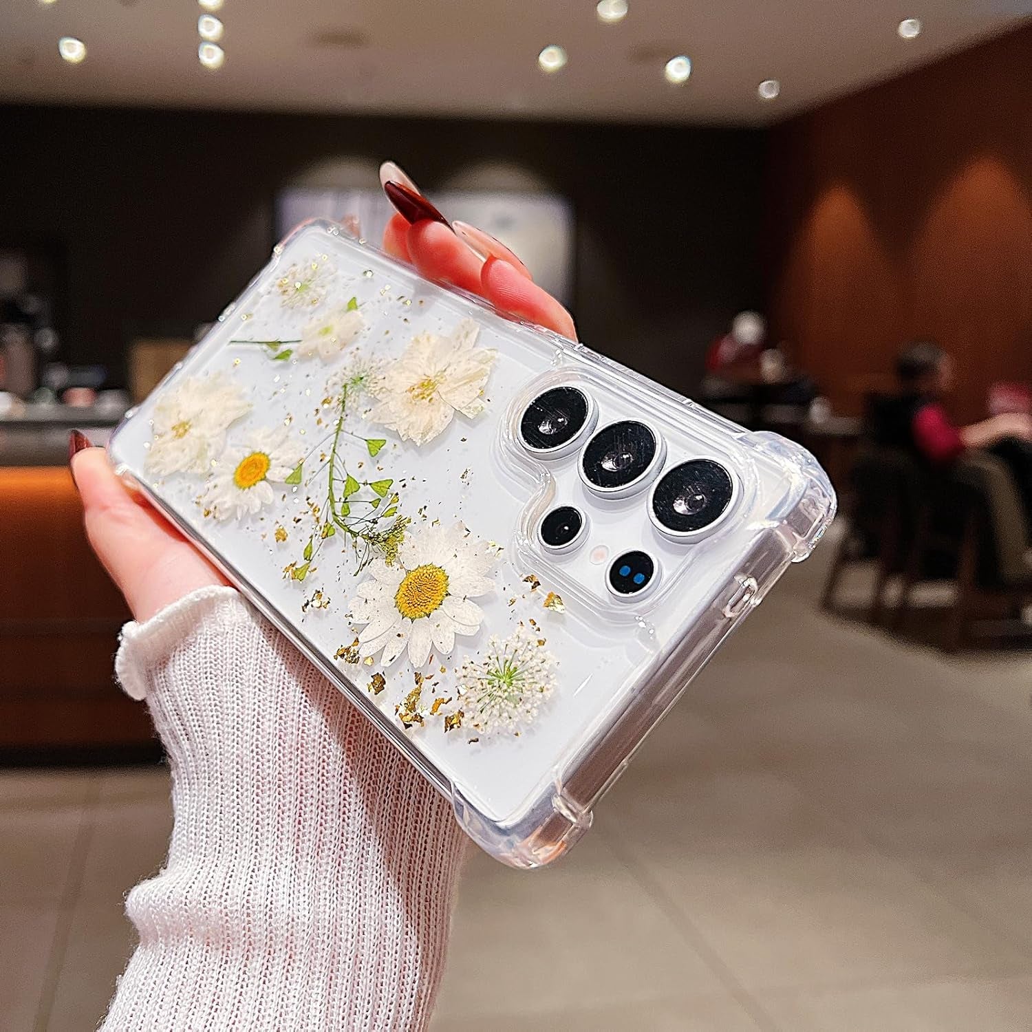 Clear Galaxy S26 Ultra case by X With Love featuring pressed dried flowers and glitter design with white floral accents.