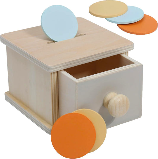 Wooden Montessori coin box toy for 1-year-old toddlers, featuring a ball drop and drawer for object permanence learning.