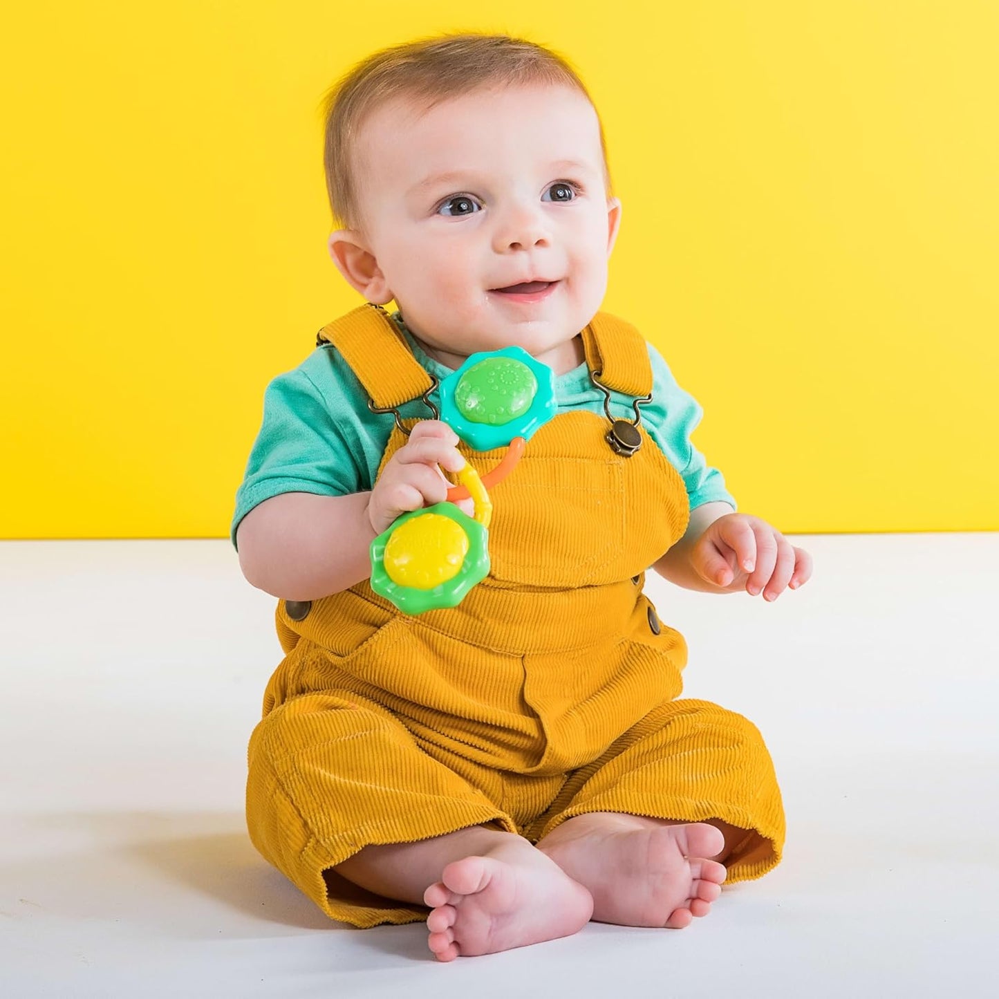Green Rattle & Shake Barbell toy for babies age 3 months and up, featuring colorful, soft plastic parts for sensory play.