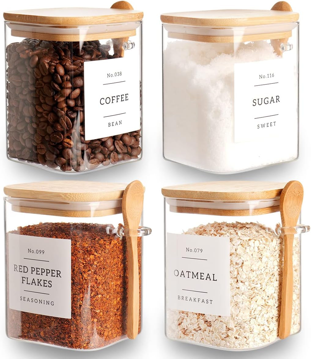 Set of 4 square glass storage jars with bamboo lids and spoons, labeled for coffee, tea, and sugar, in a kitchen pantry.