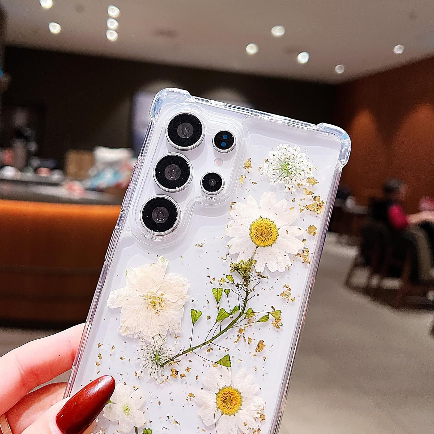 Clear Galaxy S26 Ultra phone case with white pressed dried flowers, glitter accents, shockproof design, and floral pattern by X With Love