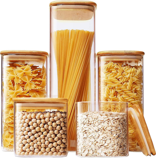 Set of five square glass jars with bamboo lids for kitchen storage, ideal for pasta, cereal, flour, and sugar.