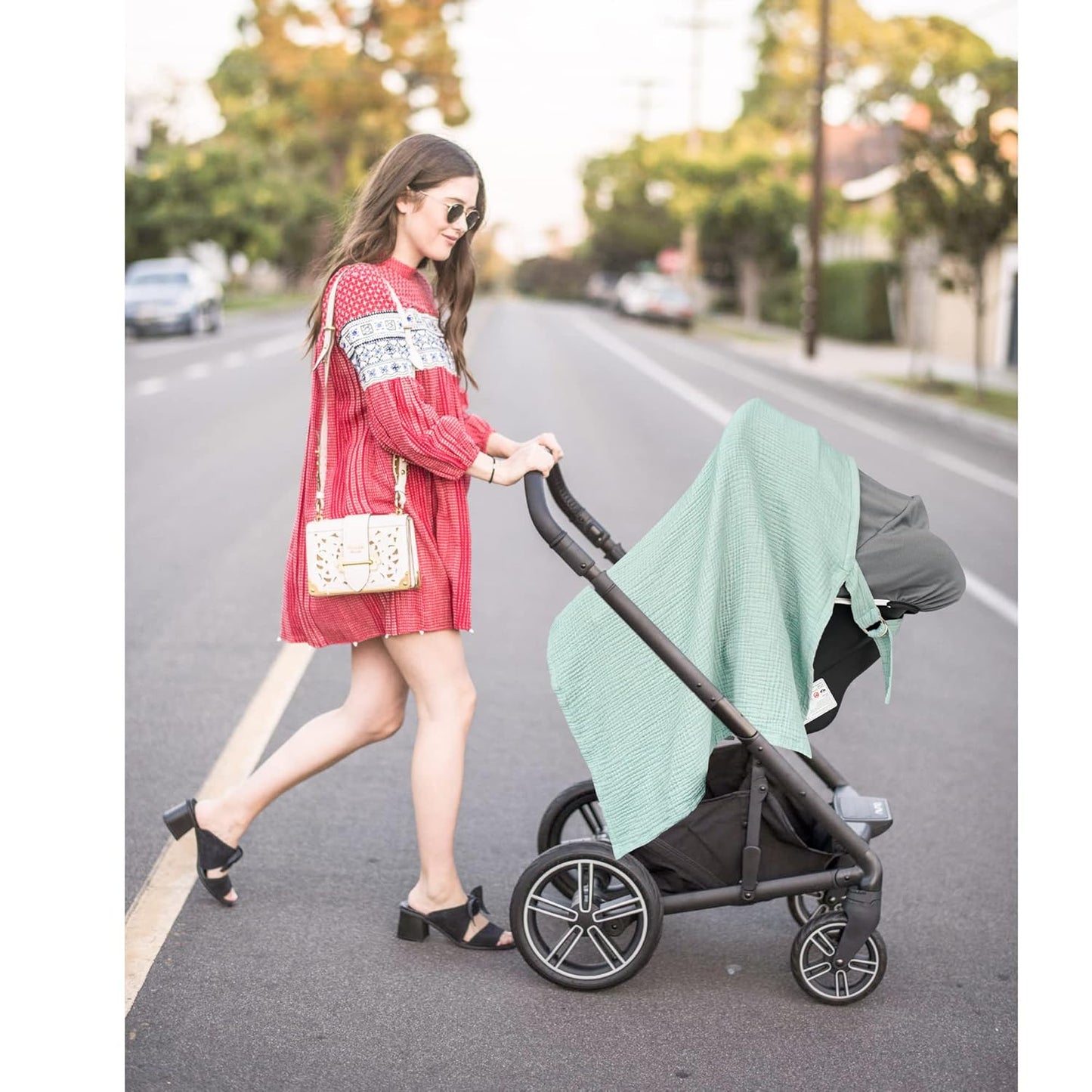 Breathable green muslin nursing cover with rigid hoop for breastfeeding, made of 100% cotton, suitable as a carseat canopy.