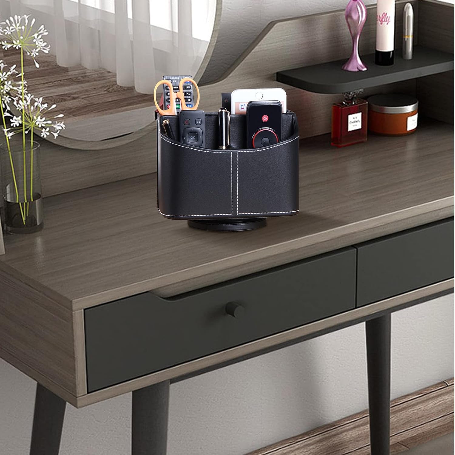 Leather remote control holder with 360-degree spinning design, organizing TV remotes, phones, pens, and small items on a bedside table.