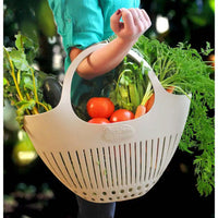 Pink garden colander harvest basket with handles, perfect for gathering and rinsing fresh produce in the garden.