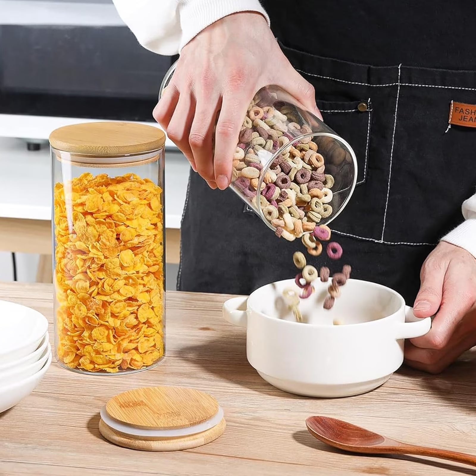 Six 25oz glass jars with bamboo lids for food storage, containing coffee, sugar, flour, candy, pasta, and spices.